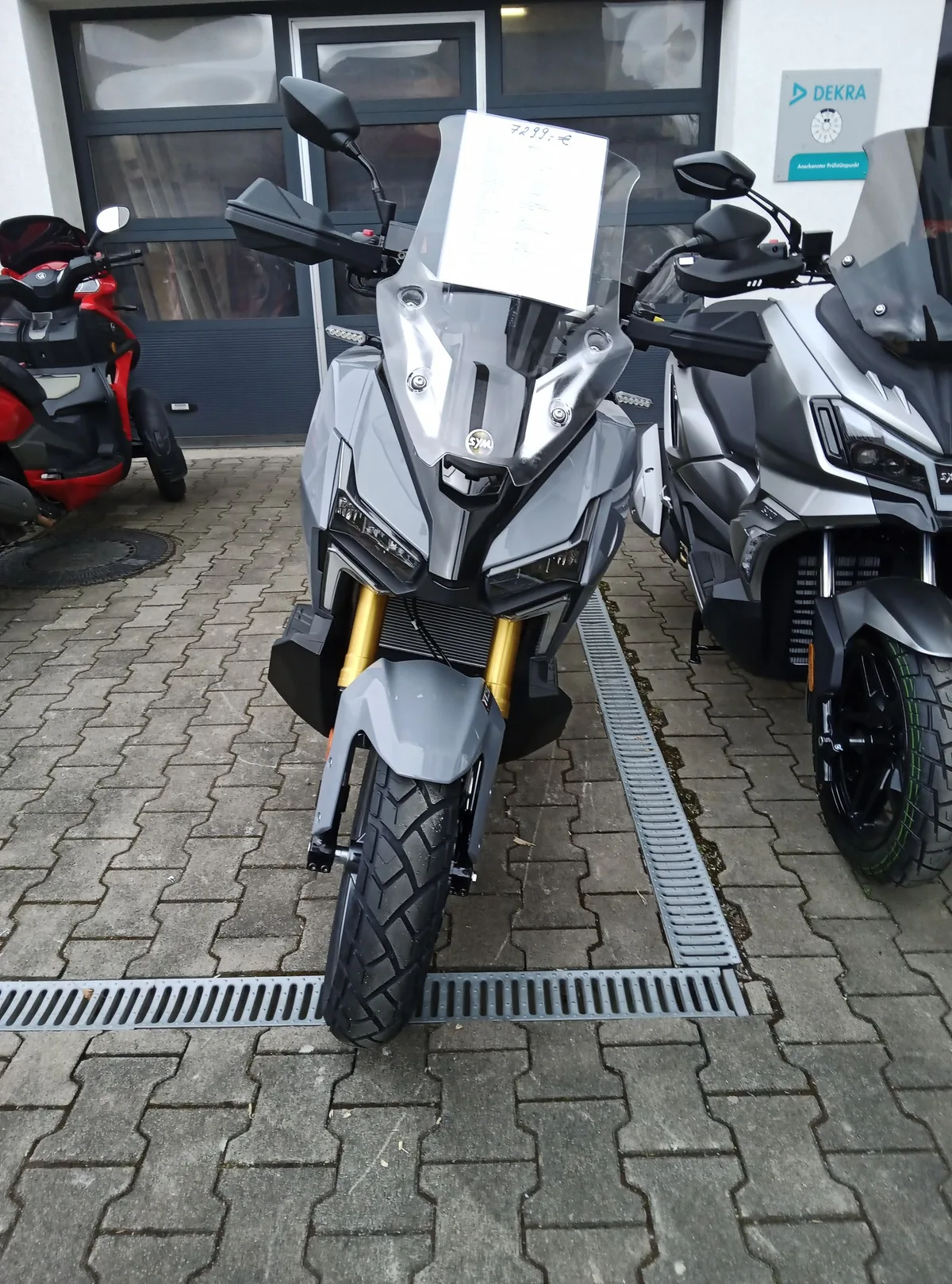 Grauer Adventure-Roller mit Windschild von vorn auf dem Hof