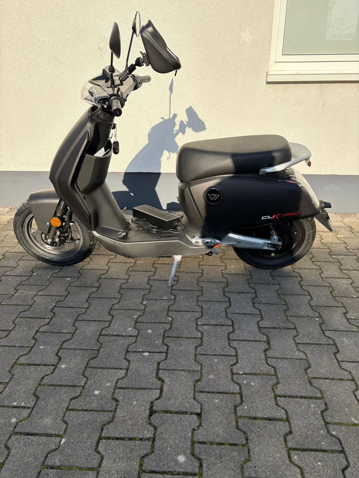 Roller in Anthrazit mit Trittbrett auf dem Hof der Werkstatt